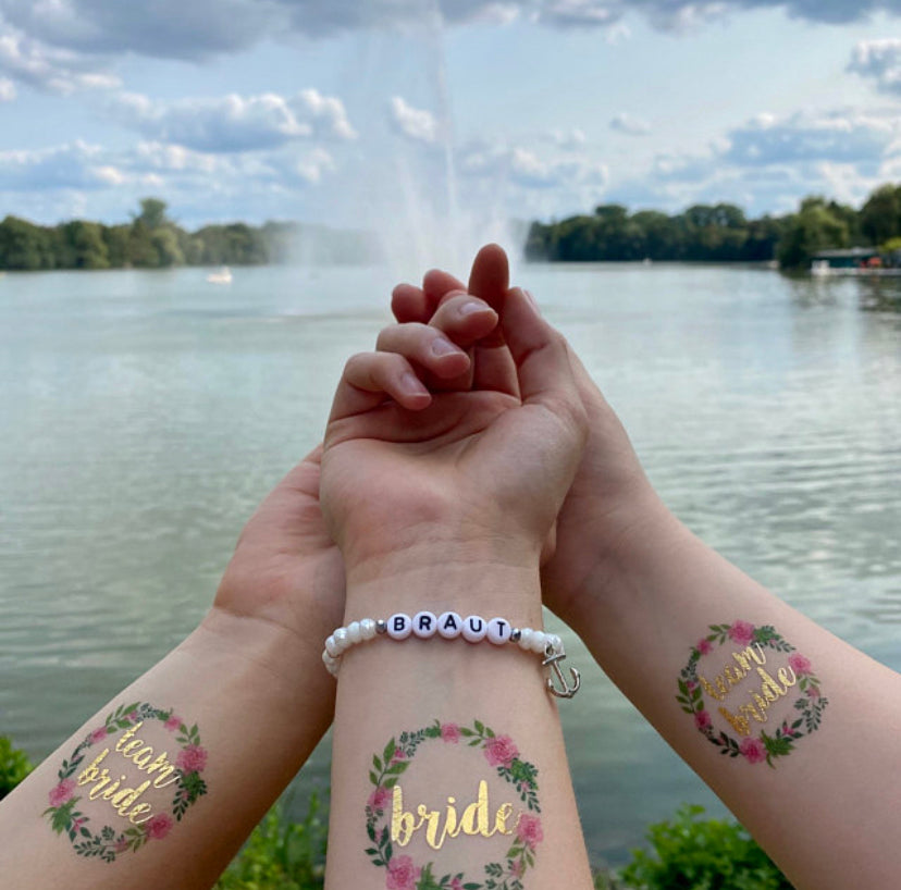 JGA-Tattoos im Blumenkranz-Design mit goldenem Schriftzug für Junggesellinnenabschied und Bachelorette Party