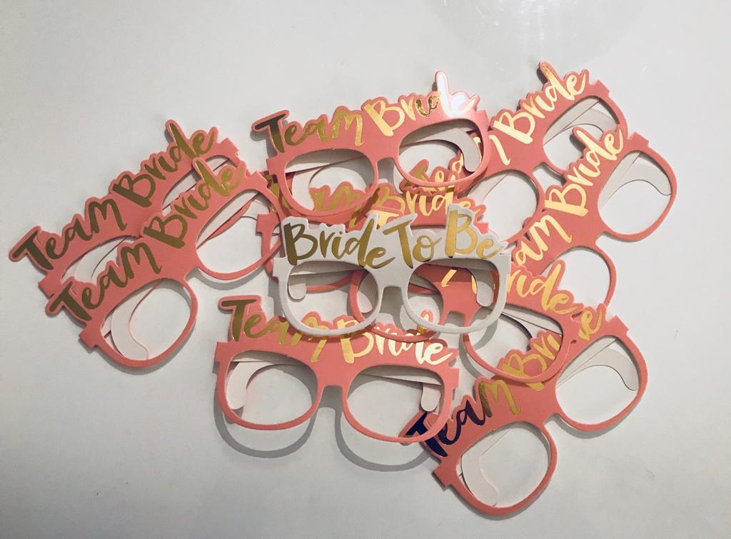 JGA Party-Brillen Set mit 1x weißer Bride To Be und 9x rosafarbener Team Bride Brille, Goldschriftzug